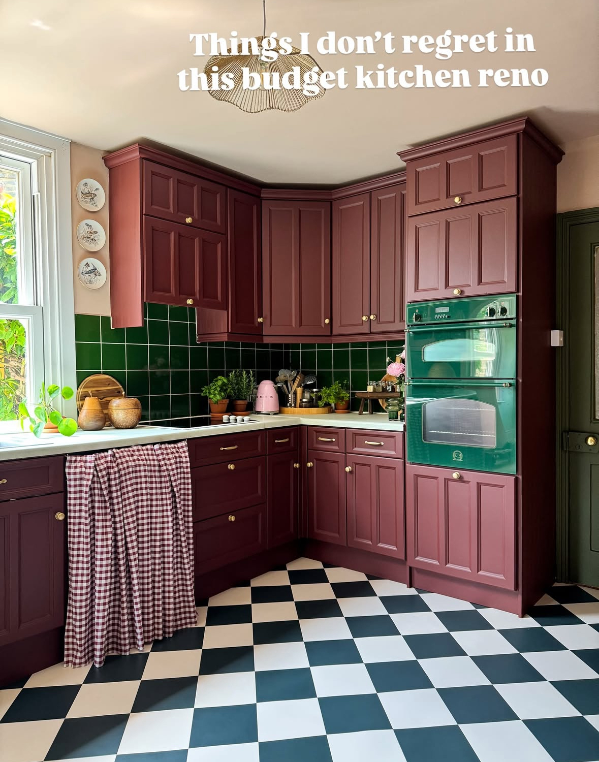 Colourful kitchen with burgundy cabinets, original green tiles and a new black-and-white checkerboard floor styled by @thistimeincolour.