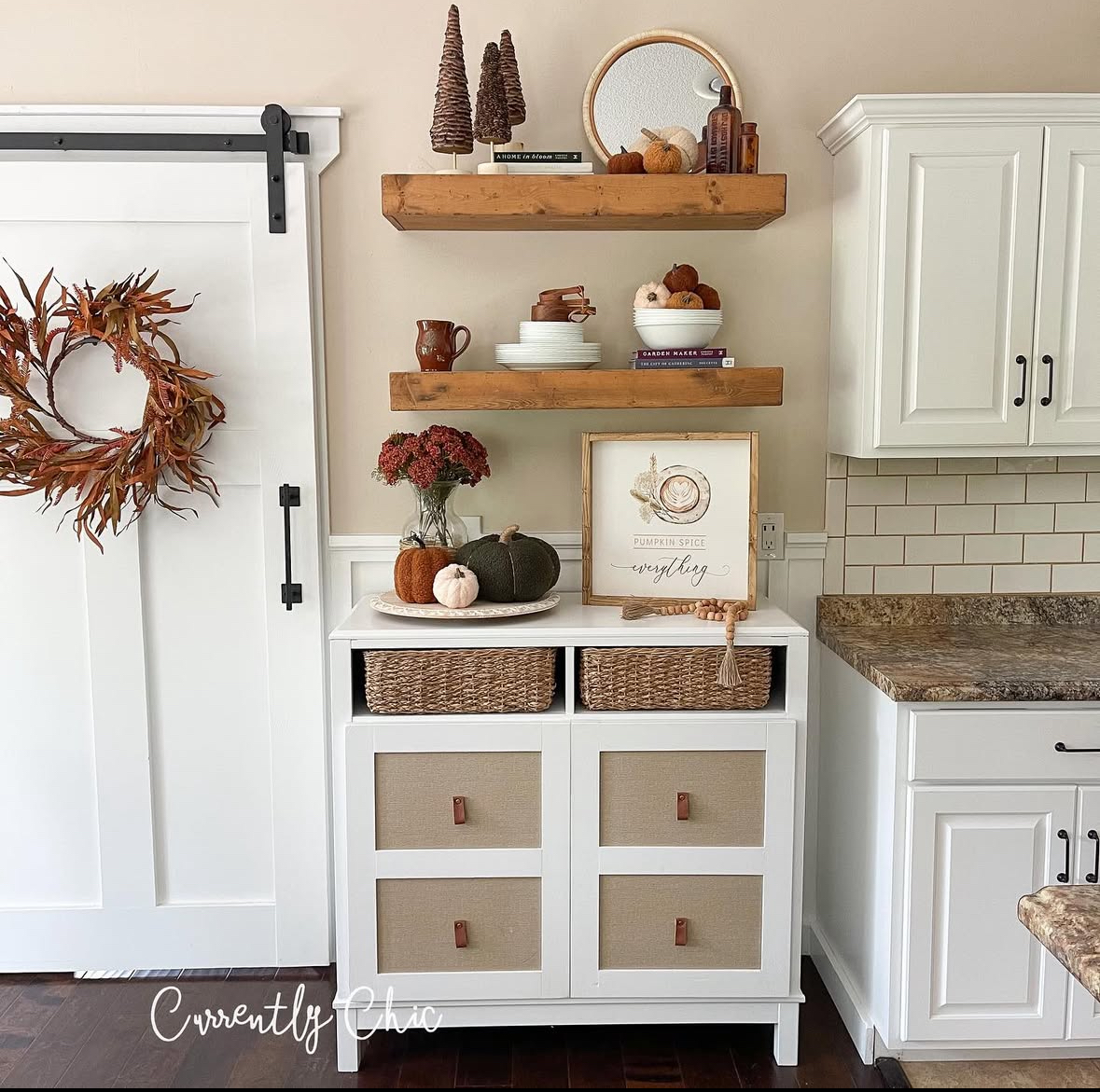 Console with two chunky wood shelves, pumpkins, books, and a “pumpkin spice everything” print beside a barn door wreath.