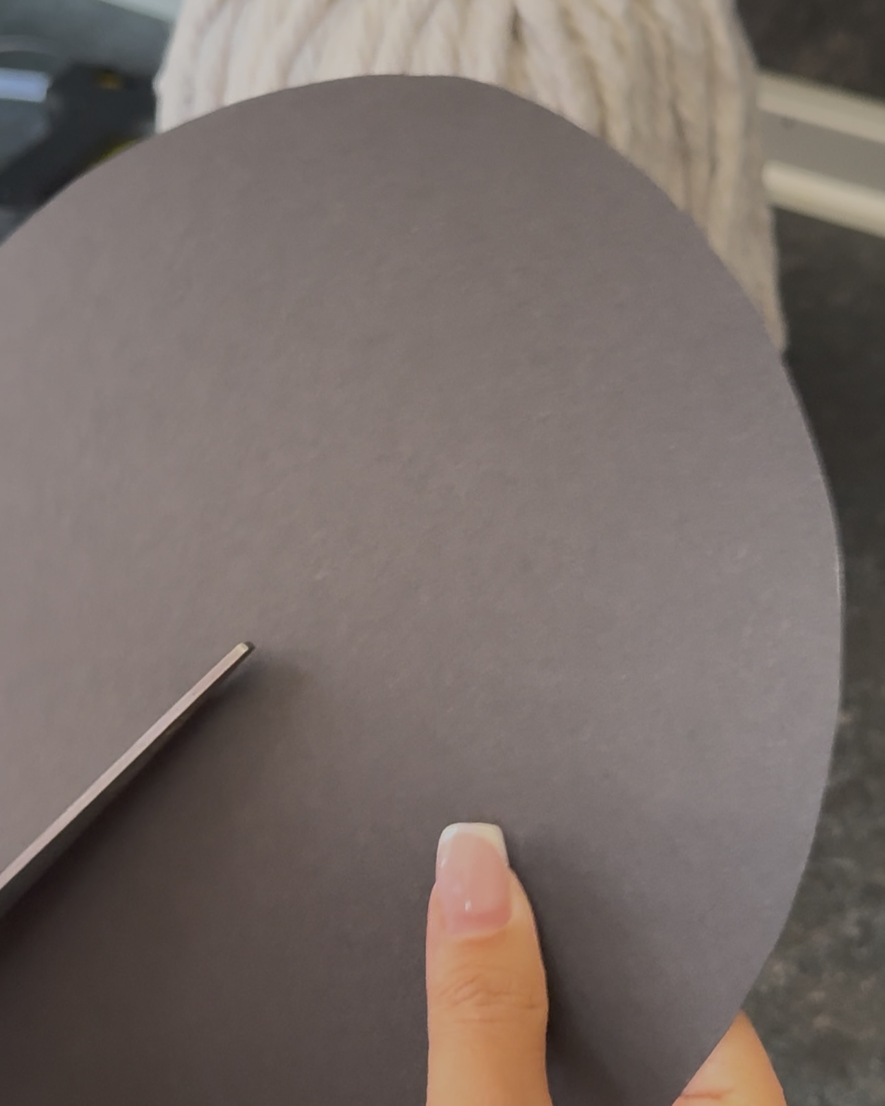 Cutting a large black paper circle to make the witch hat brim.