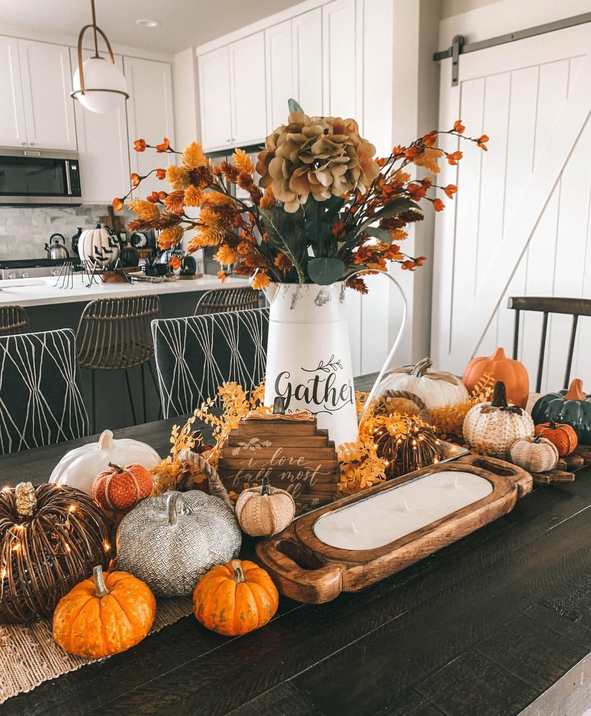 Textured pumpkin centerpiece with wicker, knit, and ceramic pieces plus a dough-bowl candle.
