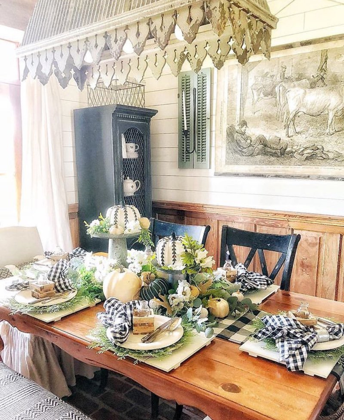 Farmhouse tablescape with black-and-white gingham, greenery, and creamy pumpkins.