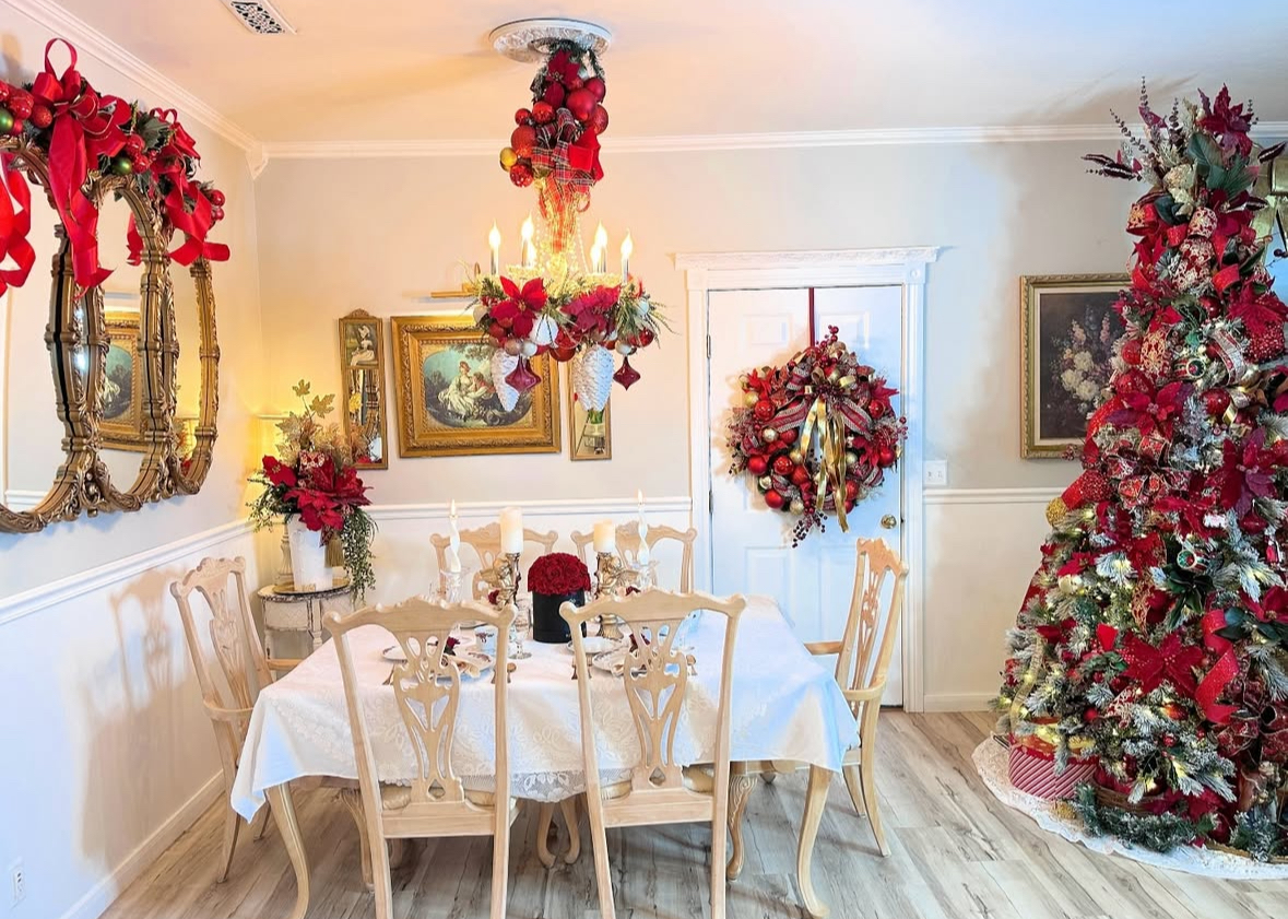 Red-and-gold maximalist dining room with ornamented chandelier—bold dining room Christmas decorating ideas.