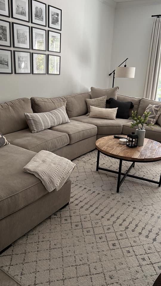 Assorted stylish wall decor elements mounted above a couch, including typography and photo frames