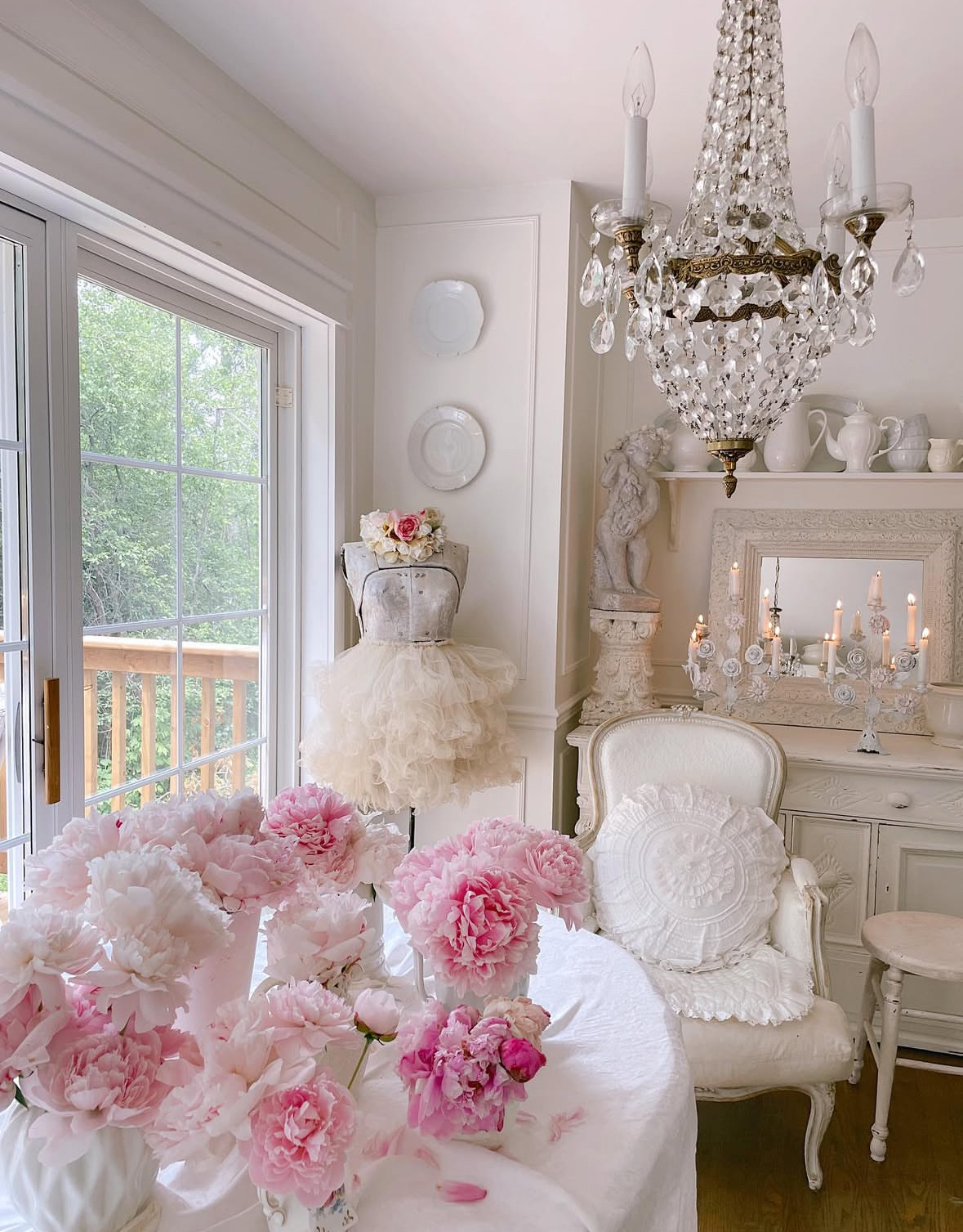 White parlour with crystal chandelier, dress form, and peonies as romantic shabby chic home decor ideas.