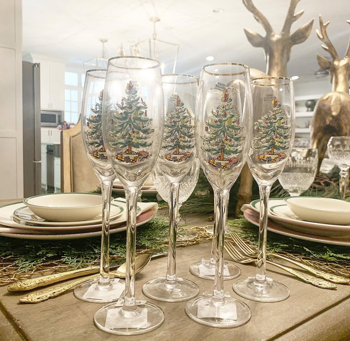 Champagne and taupe tablescape with candles, greenery, and blush-gold ornaments for a soft, elegant look.