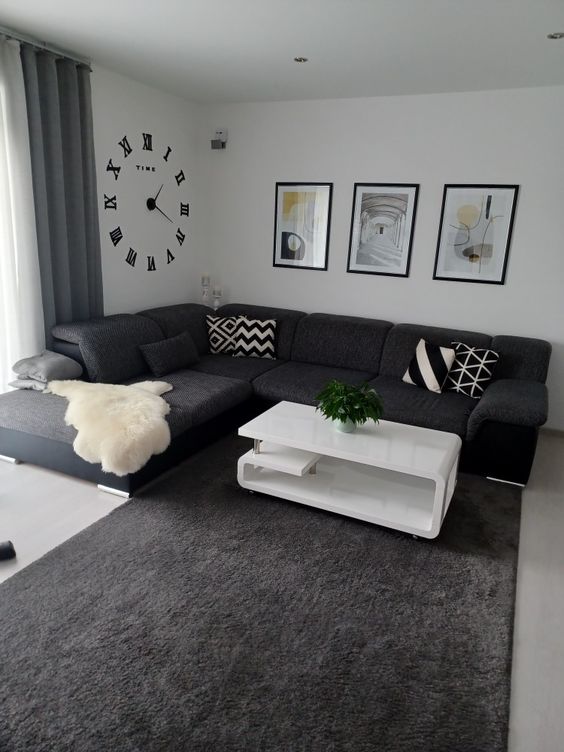Gallery of decorative wall pieces including mirrors and canvases above a black couch