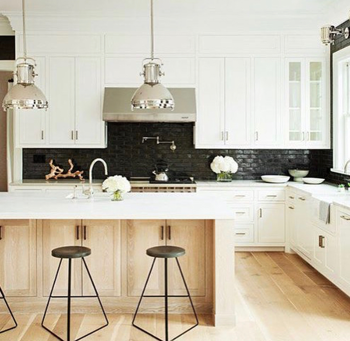 Glossy black brick backsplash in a bright white kitchen
