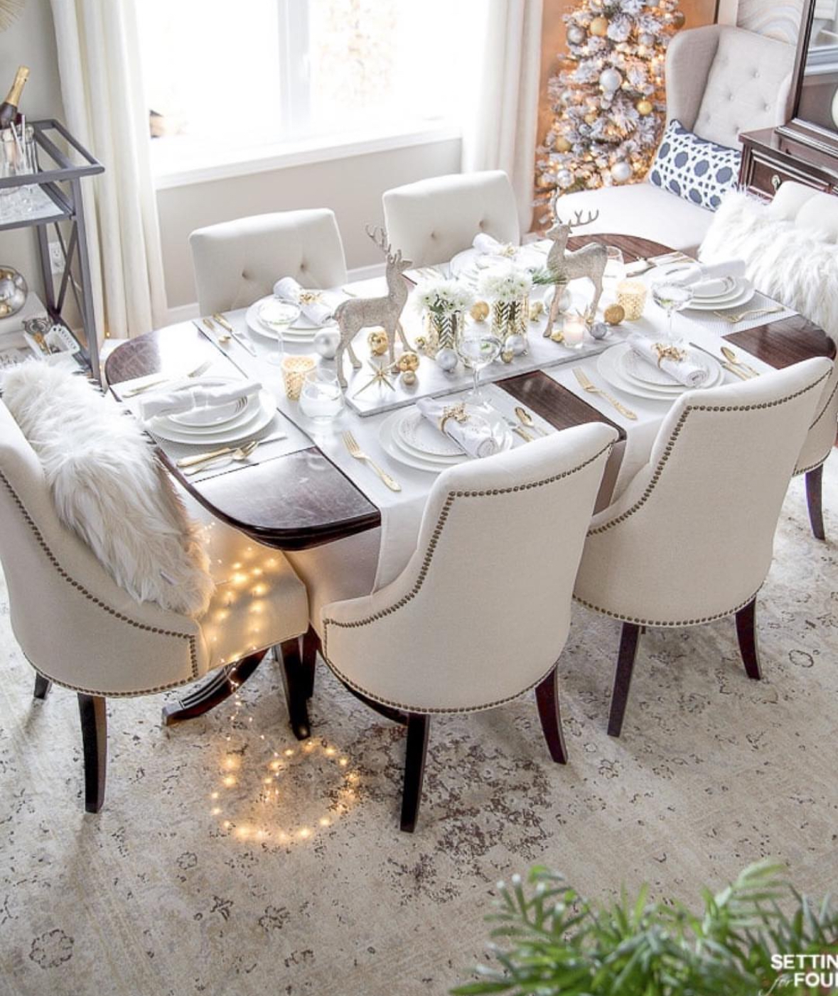 White-and-gold table with metallic ornaments illustrating Christmas decoration ideas for dining room.