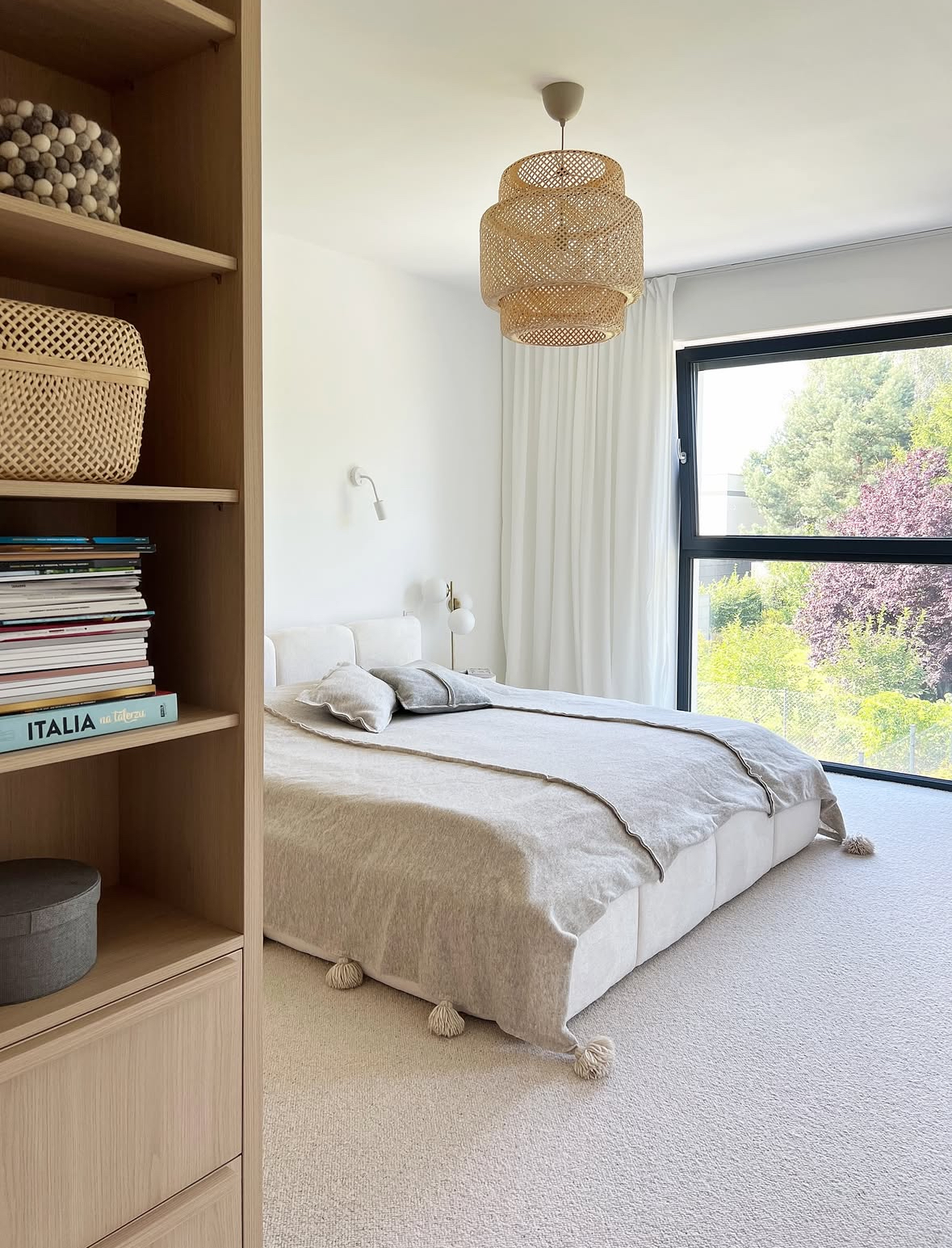 Scandinavian-Japandi bedroom with a bright window and tassel throw